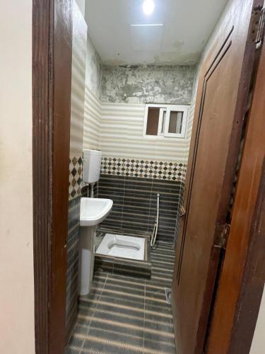 a small bathroom with a toilet and a sink at Sherazi Arcade in Islamabad