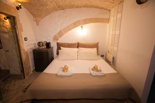 a bedroom with a bed with two boxes on it at Suite Pietra Bianca - Relax & SPA in Martina Franca