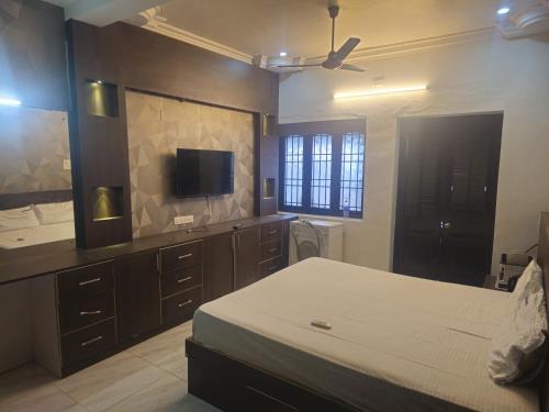 een slaapkamer met een bed en een flatscreen-tv bij SALT classic beach resort in Kālapettai