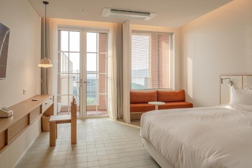 콘스트호텔 في Hyŏpchae-ri: غرفة نوم بها سرير وأريكة ونافذة