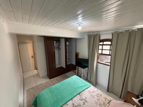 een kleine slaapkamer met een bed en een raam bij casa dos MORAIS in Angra dos Reis