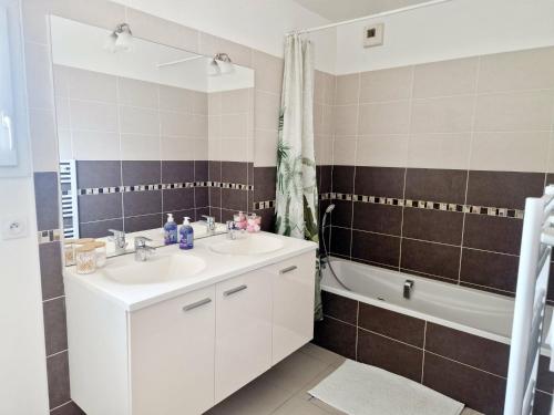 a bathroom with a sink and a tub and a toilet at Villa Cosy T5, Calme avec Jacuzzi XL in Nîmes