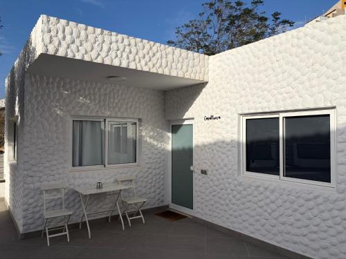 a white building with chairs and a table on a patio at Casa Nueva in Las Palmas de Gran Canaria
