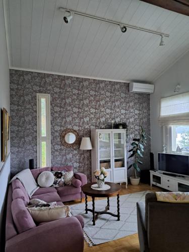 un soggiorno con un divano viola e un tavolo di Villa Hammar a Sulkava