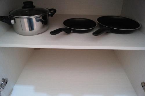 a shelf with two pans and a pot on it at MV Suites in Monterrey