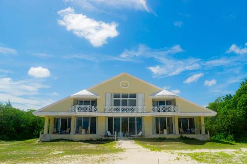 a house on the beach with a blue sky at Puerta del Mar Cozumel in Banco Playa