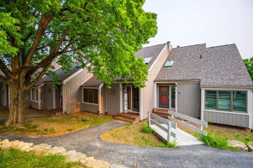 a home with a tree and a house at Hideaway Cove in Galena