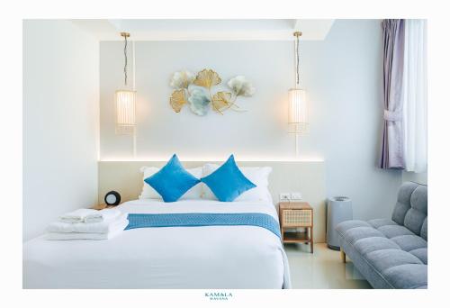 a bedroom with a bed with blue pillows and a couch at Kamala Havana Hotel and Cafe in Kamala Beach