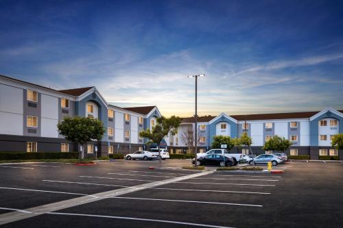 a parking lot with cars parked in front of a building at Sonesta Simply Suites Irvine East Foothill in Lake Forest