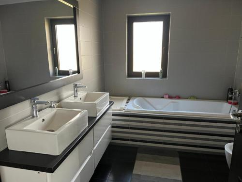a bathroom with two sinks and a bath tub at Vila Liana in Stana