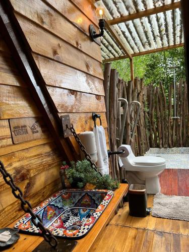 baño con aseo en una pared de madera en Valle Verde Eco, en Riofrío