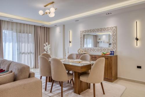 a dining room with a table and chairs and a mirror at Luxurious 3Bd Hotel Apt in compound Sheikh Zayed with Pool and Gym access in Sheikh Zayed