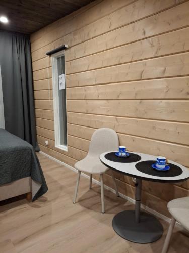 una habitación con una mesa y dos sillas y una cama en Arctic River View, en Rovaniemi