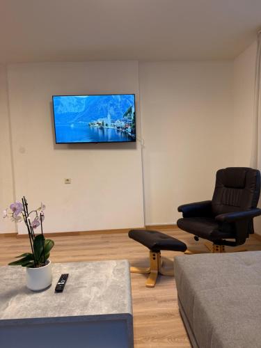 sala de estar con sofá, silla y TV de pantalla plana en Appartement Kodra, en Sonnberg