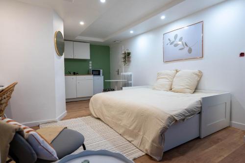 a bedroom with a large bed and a kitchen at Studio de Luxe Entièrement Neuf - Proche Paris in Gagny