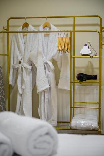a rack filled with white towels and a bed at Cambridge Gardens in London
