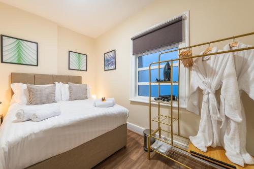 a bedroom with a large bed and a window at Cambridge Gardens in London