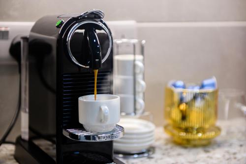 a coffee maker is pouring coffee into a cup at Cambridge Gardens in London