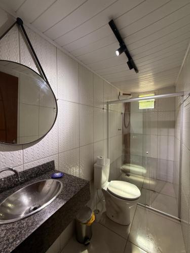 ein Badezimmer mit Toilette, Waschbecken und Spiegel in der Unterkunft Pituba Ville - Ap - 1 andar - 2/4 in Itacaré