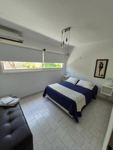 Un dormitorio con una cama y un sofá. en Carpe Diem Gonnet, en Joaquín Gorina