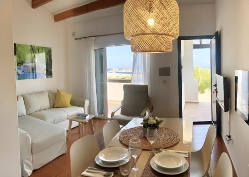 Una sala de estar con un sofá blanco y una mesa. en Costa Arenal 52, en Arenal d'en Castell