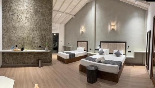 a bedroom with two beds and a bath tub at The Lavish Haven in Piyadigama