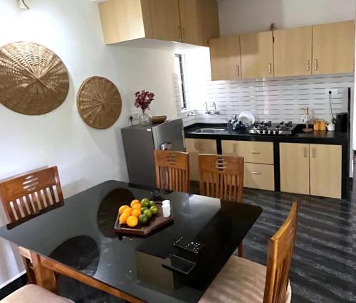 a kitchen with a table with a plate of fruit on it at Casa Palolem in Canacona