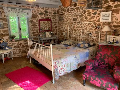 Un dormitorio con una cama, una silla y un espejo. en Chez Valérie et François, en Moux-en-Morvan