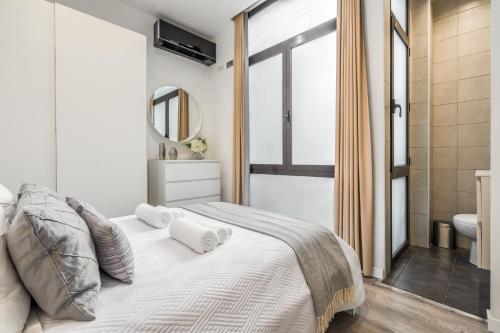 Un dormitorio blanco con una cama y un baño. en Apartamento en excelente ubicación, centro de Barcelona, en Barcelona