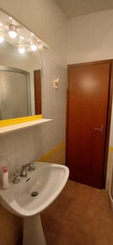 um banheiro com pia branca e espelho em Blu Mare em Punta Marina