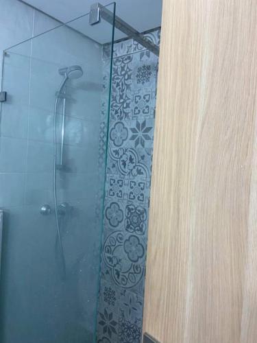 a bathroom with a shower with a glass door at Apartment kamal park E21 in Mohammedia