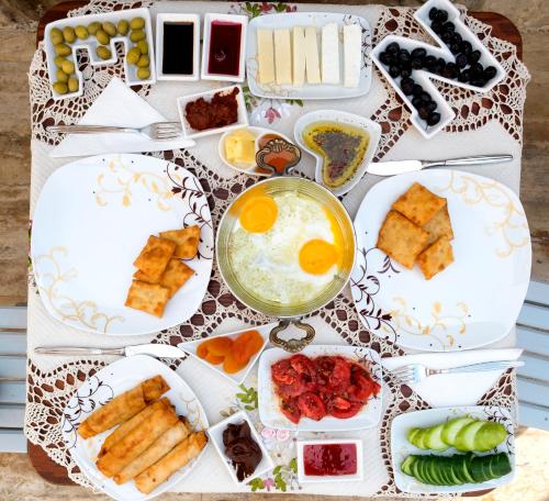 a table topped with plates of food with eggs on it at Hotel Mary's House in Selcuk