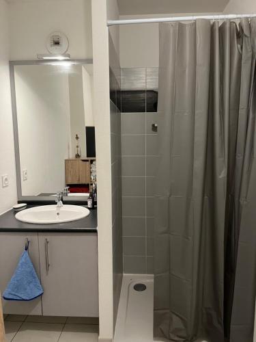 een badkamer met een douchegordijn en een wastafel bij Labenne Océan in Labenne