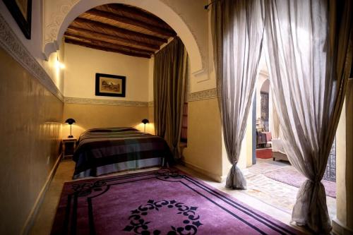 a bedroom with a bed and a large window at BKAN RIAD MARRAKECH in Marrakesh