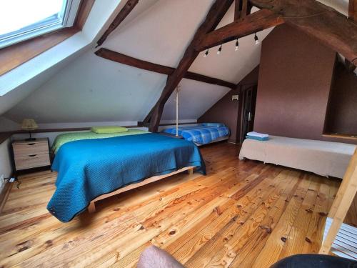 1 dormitorio en el ático con 2 camas y suelo de madera en Maison proche de la gare, en Lisieux