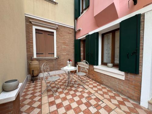 a patio with a table and chairs in a building at Ca' Dolce Rosa in Burano