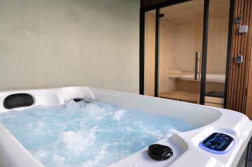 e bagno con vasca riempita di acqua blu. di Boavista Gem Villa a Porto