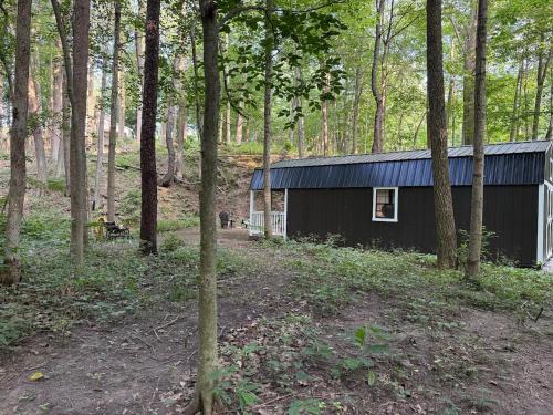 ein schwarzes Gebäude mitten im Wald in der Unterkunft Creekwood Cottage in Peru