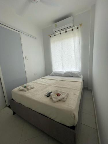 a small bedroom with a bed with a window at Hotel Casa Colonial Moñitos in Moñitos