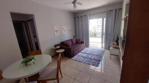 AP bem localizado na Praia do Canto في فيتوريا: غرفة معيشة بها أريكة وطاولة