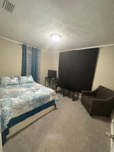 8mins from Jaguar stadium & the Historical Riverside في جاكسونفيل: غرفة نوم بها سرير وكرسي