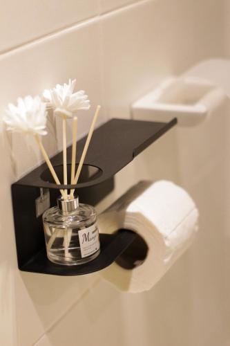 a bathroom with a toilet with a roll of toilet paper at House of Keul - 2BR cozy condo in Dumaguete with pool and free laundry for long term guests up to 4 pax in Piapi