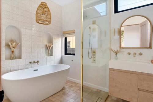 a bathroom with a large white tub and a sink at Bohemian Dream Studio Close to LA Stadium SOFI Kia Forum Intuit Dome LA Coliseum in Los Angeles