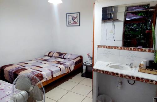 a small bedroom with a bed and a sink at Homestay Tarapoto in San Antonio