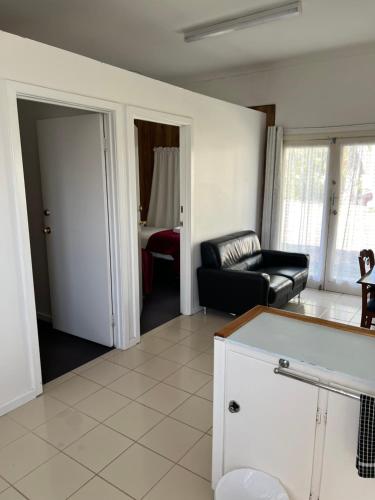 una sala de estar con un sofá y una mesa en Restawile Motel, en Busselton