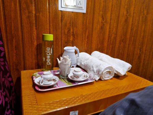 Pawna Tent Camp by Maitri Pawna Lake في Kolvan: صينية مع مجموعة الشاي على طاولة