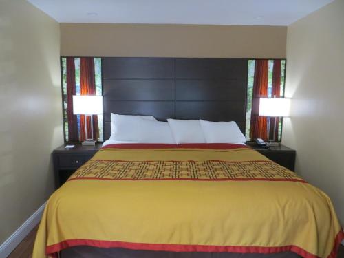 a bedroom with a large bed with two lamps at Muir Woods Lodge in Mill Valley