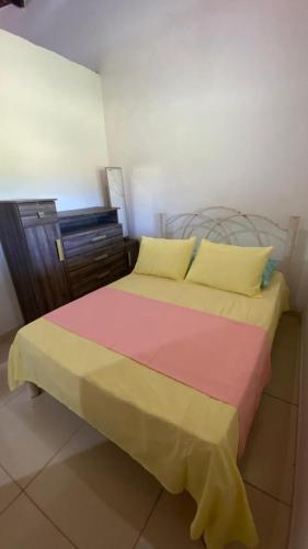 a bedroom with a bed and a dresser at Casa em Porto de pedras in Tatuamunha