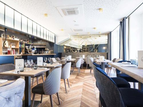a restaurant with tables and chairs and a bar at MADISON Saint Jean de Luz - Handwritten Collection in Saint-Jean-de-Luz