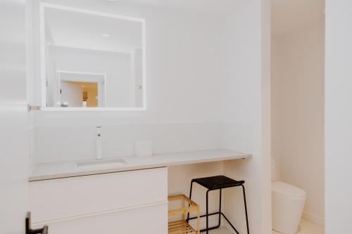 a white bathroom with a sink and a mirror at Luxury 1BR at Red Mountain Ski-Bike Sauna in Rossland